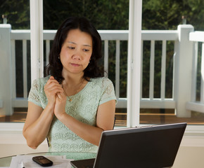 Mature woman looking at computer screen while working from home