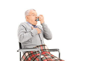 Wall Mural - Senior man breathing through his inhaler