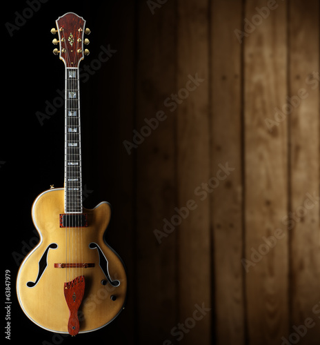 Board z aluminiowym obramowaniem Jazzowa gitara na ciemnym drewnianym tle