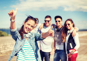 Wall Mural - teenage girl with headphones and friends outside