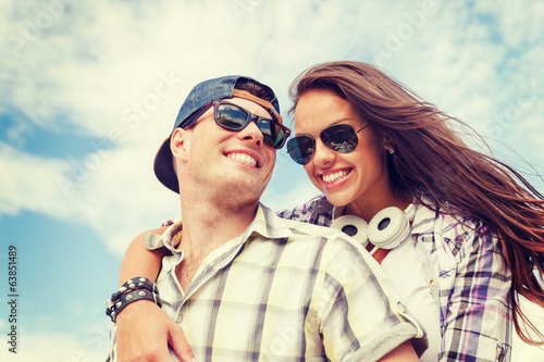 Fototapeta na wymiar smiling teenagers in sunglasses having fun outside