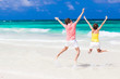 © el.rudakova - Young couple in bright clothes jumping on the beach