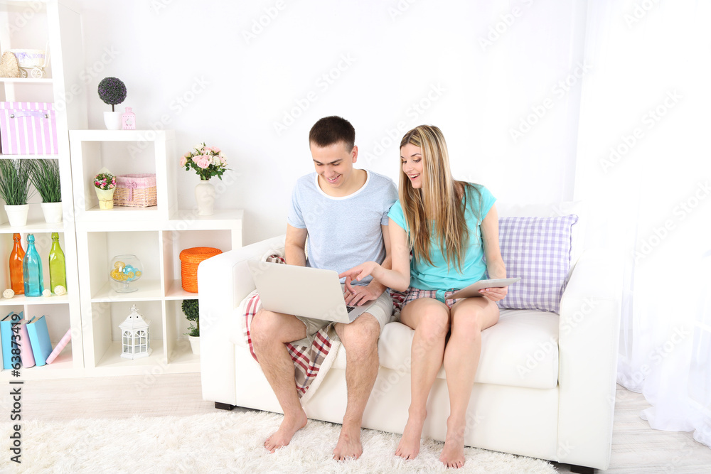 Loving couple  relaxing with laptop  and tablet,
