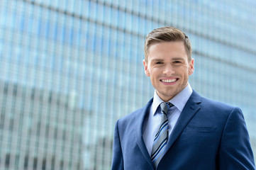 Wall Mural - Smart young businessman looking at camera