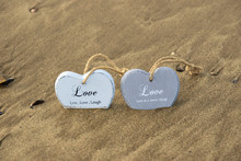 Two Inscribed Wooden Love Hearts In The Quick Sand