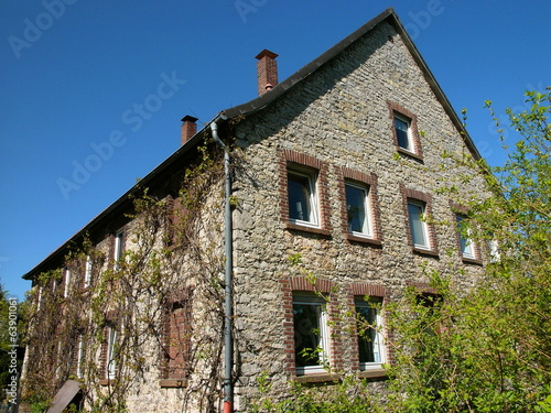 Altes Bauernhaus im Grünen mit Bruchsteinfassade in Helpup Stock-Foto