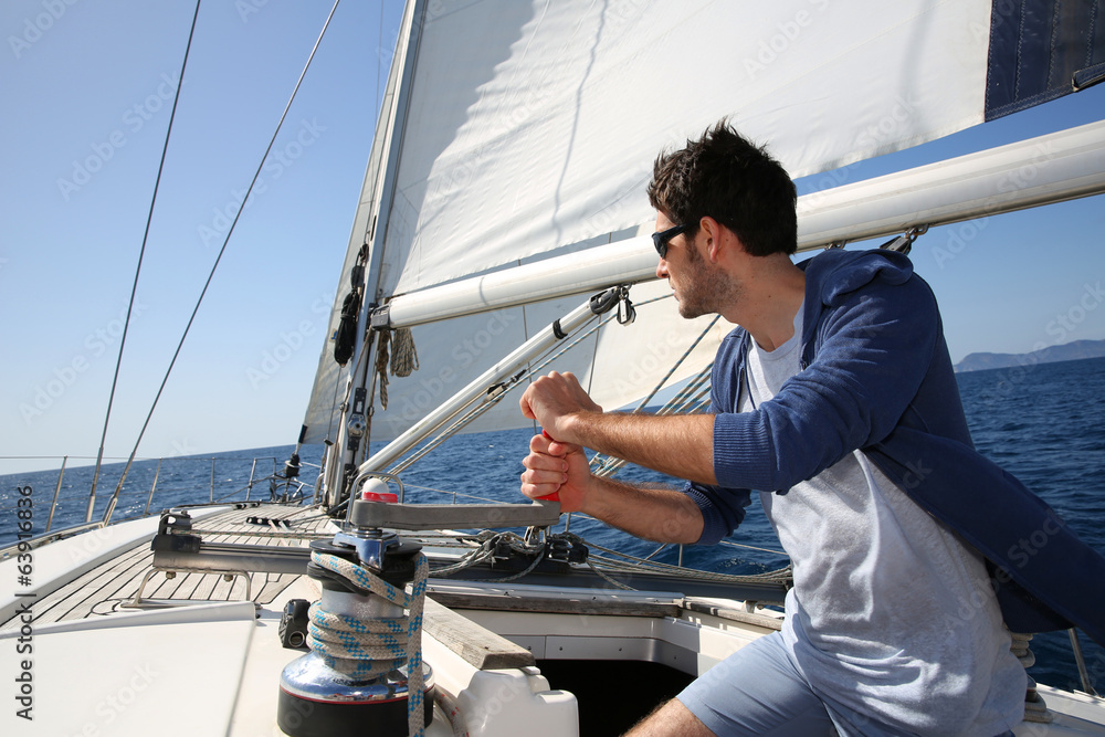 Man sailing with sails out on a sunny day - obrazy, fototapety, plakaty 