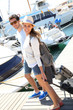 Happy couple getting on board for sailboat cruising