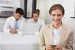 © lightwavemedia - Businesswoman text messaging with colleagues at office desk