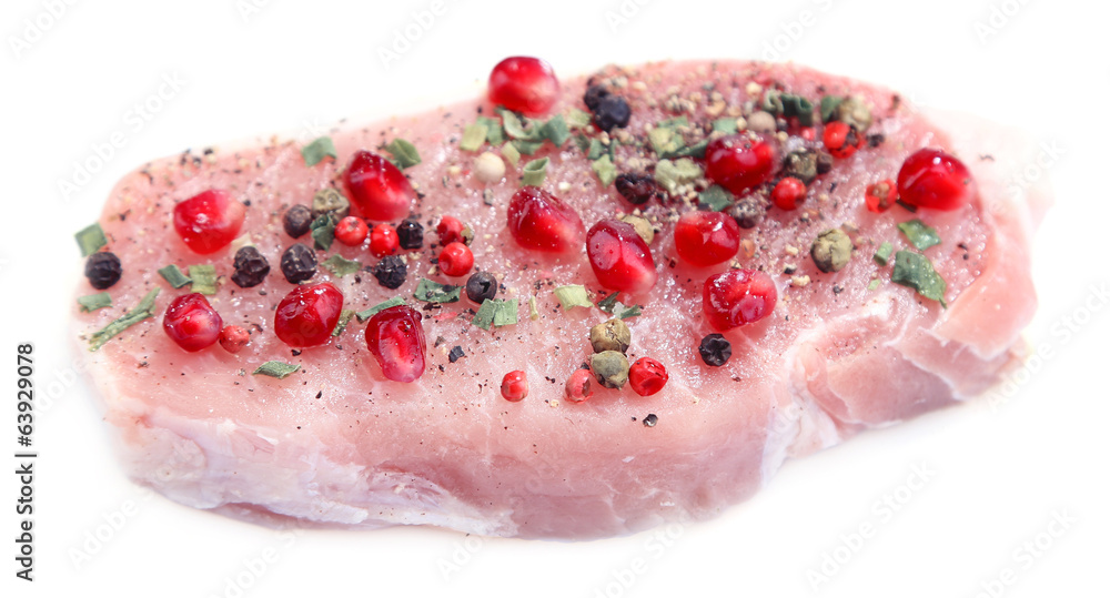 Raw meat steak with spices and pomegranate seeds, isolated