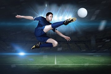 Wall Mural - Composite image of football player in blue kicking