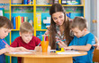 © spass - Cute children drawing with teacher at preschool class
