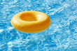 floating ring on blue water swimpool with waves reflecting