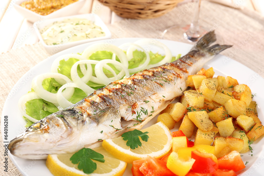 Delicious grilled fish on plate on table close-up