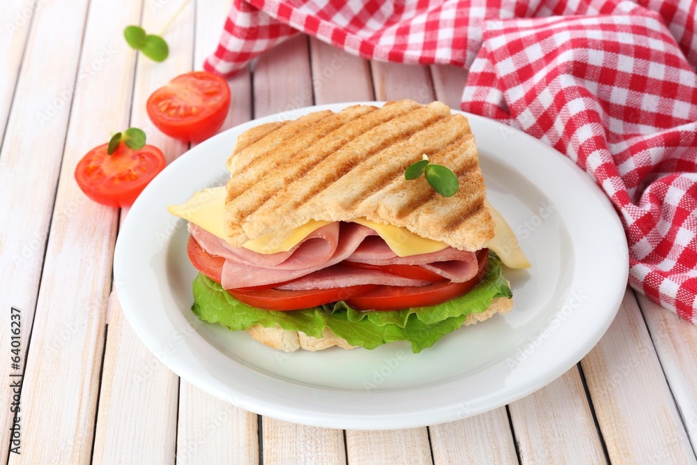 Tasty sandwich with ham on wooden table
