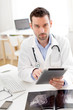 © Production Perig - Portrait of a young doctor using tablet at work