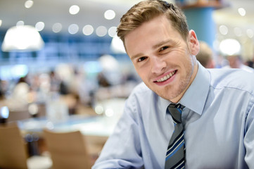 Wall Mural - Smiling young man relaxing in restaurant