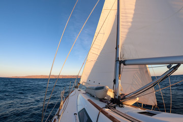 Wall Mural - Sailboat crop during the regatta at sunset ocean