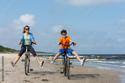 Fotoboard na płycie Nastoletnia dziewczyna i chłopiec jechać na rowerze na plaży