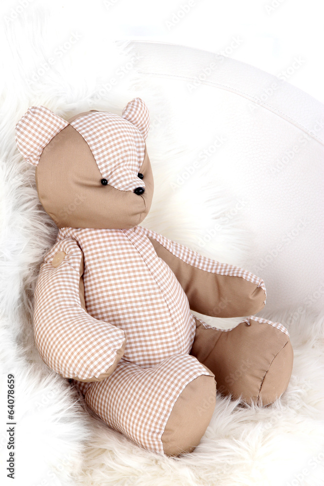 Bear toy on armchair in room