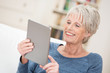 entspannte ältere frau liest ein ebook