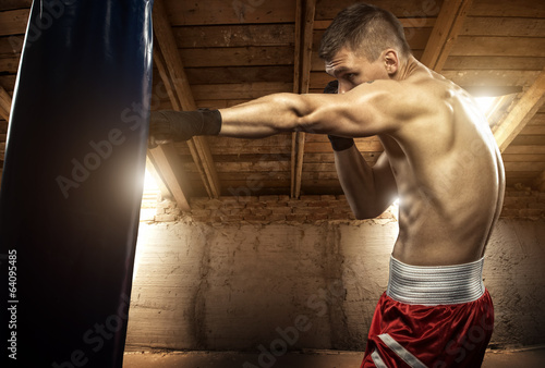 Obraz w ramie Young man boxing, exercise in the attic