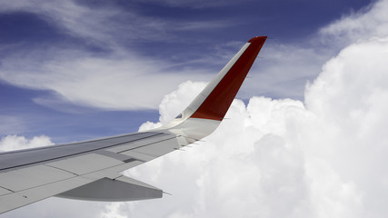 View from airplane window with blue sky and white clouds