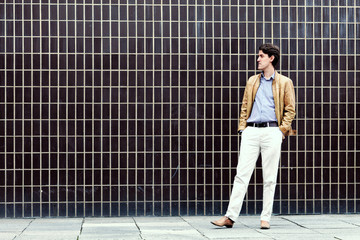 Young man standing next to a wall