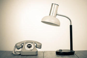 Fototapete - Retro telephone and desk lamp on table