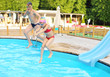 © Pavel Losevsky - Happy boy and girl jumping into the swimming pool