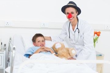 Wall Mural - Doctor in clown costume with boy in hospital