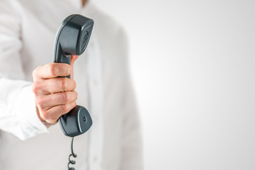 Man holding a landline telephone receiver