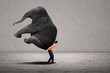 Business leader lifting elephant on grey