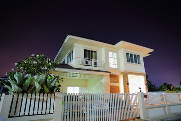 Big house open light in suburbs at night