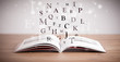 © ra2 studio - Opened book with flying letters