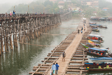 SANGKLABURI-JAN 26: Unidentified travellers on wooden bridge in