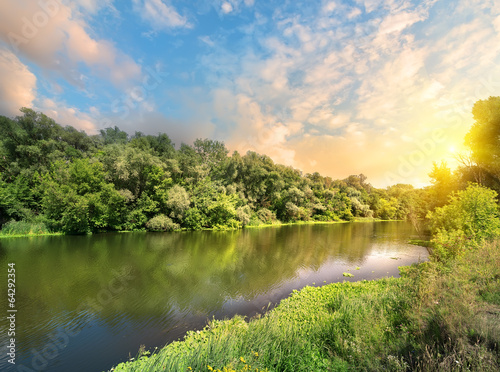 Plakat na papierze fotorealistycznym Słońce w chmurach nad rzeką