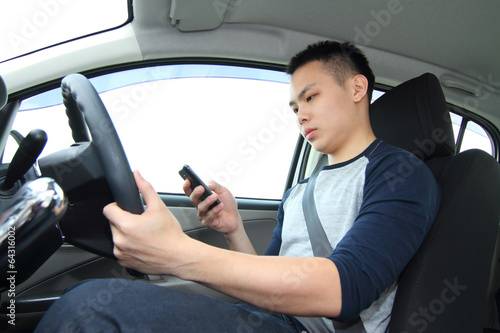 Fotografie, Obraz A male driver texting on a cellphone while driving