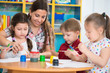 © spass - Cute children drawing with teacher at preschool class