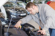 © M-Production - Man examining new car at the dealership.