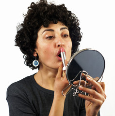 Woman putting on lipstick