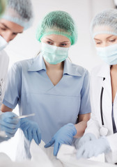 Poster - young group of doctors doing operation