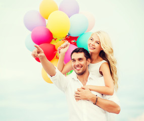 Poster - couple with colorful balloons at sea side