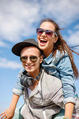 Wall Mural - smiling teenagers in sunglasses having fun outside