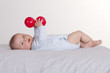 6 months old baby boy holding two red balls