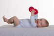 6 months old baby boy holding two red balls