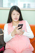 © zhu difeng - Photo of pregnant woman lying and looking at cellphone