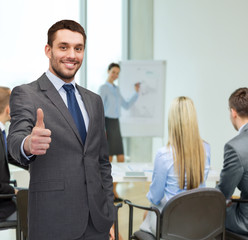 Poster - handsome buisnessman showing thumbs up in office