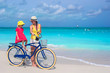 © travnikovstudio - Happy mother and her daughter riding bicycles on a tropical