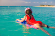 © travnikovstudio - Little adorable girl on a surfboard in the turquoise sea